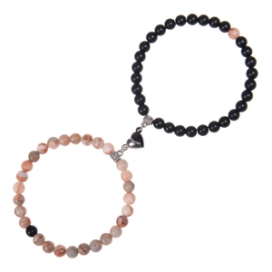 Macro detail of magnetic heart clasp on braided pink zebra stone couple bracelets
