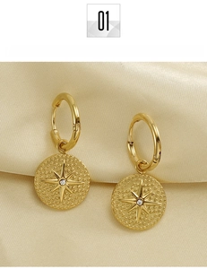 Detailed shot of 18K gold plated titanium steel earrings with embossed starburst and zircon