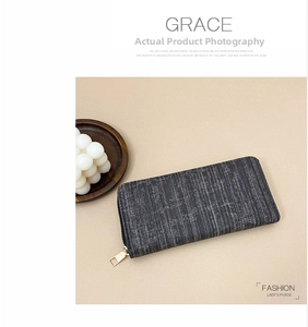 Detailed close-up of textured grey striped fabric and gold zipper on long wallet