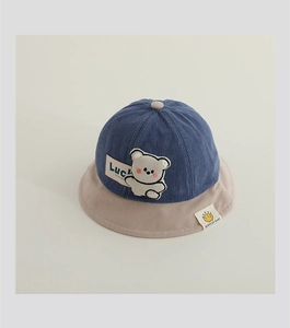 Detail of corduroy baby sun hat featuring cute bear embroidery and contrast stitching