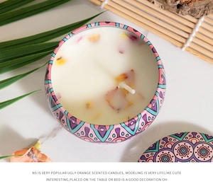Top view of a bohemian tin candle with dried flower petals and purple geometric patterns