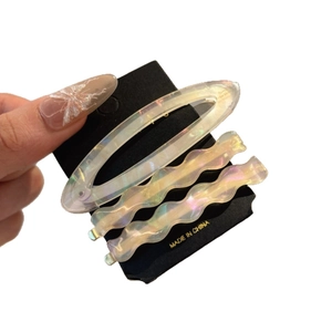 Three-piece acetate hair clip set with iridescent aurora finish on display card