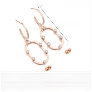 Dettaglio di orecchini ovali in oro rosa con zirconi incastonati e finitura lucida