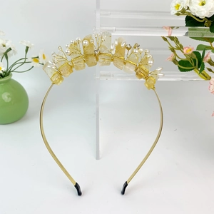 Detail of handmade gold wire crown with raw yellow crystals and white pearls