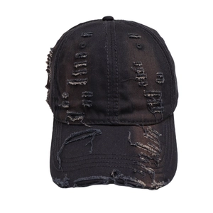 Detailed view of the distressed edges and rip effects on a black washed cotton baseball cap