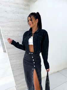 Détail de la jupe en jean noire avec boutons à l'avant et fente stylée moderne