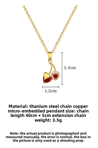 Detailed view of gold cherry pendant with red heart crystals and white zircon accents
