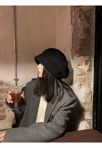 Detail of black chunky knit beanie showing thick woolen texture and slouchy fit style