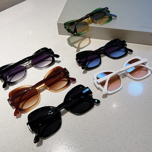 Detailed overhead view of vintage square sunglasses in black, white, and amber colors