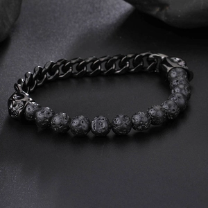 Macro detail of men's bracelet with black volcanic lava beads and metal skull chain links