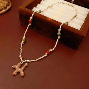 Detail of woven cotton necklace with brown ceramic H-pendant inside a jewelry box