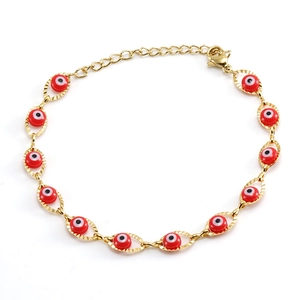 Détail d'un bracelet en chaîne dorée avec perles rouges œil turc et fermoir homard