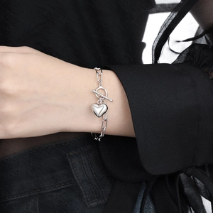 Minimalist silver heart charm bracelet with OT toggle clasp on a female wrist