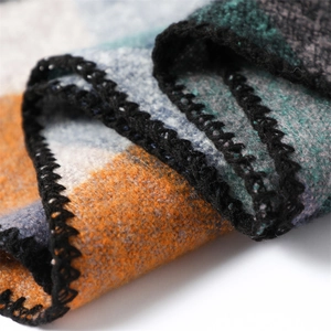 Close-up of color block cashmere-like scarf with black overlock stitching detail