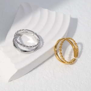 Close-up of double-layered wavy and beaded titanium steel rings on a minimalist stand