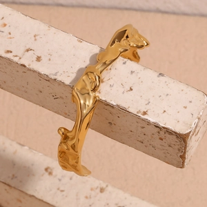 Detail of 18K gold plated stainless steel cuff with irregular hammered texture on stone