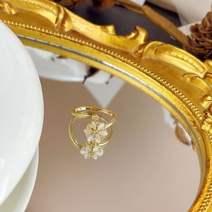 Detailed close-up of rotating cat-eye flower ring with gold finish and crystal accents