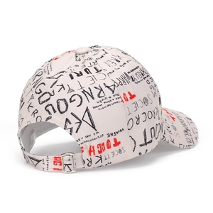 Detail of adjustable metal buckle and graffiti print on the cream baseball cap
