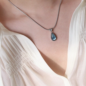 French style silver snake chain necklace featuring a deep blue teardrop gemstone pendant