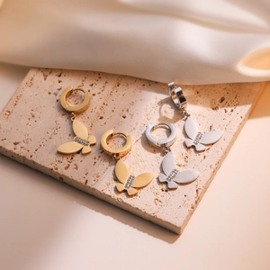 Minimalist gold and silver butterfly earrings with sparkling crystals on stone
