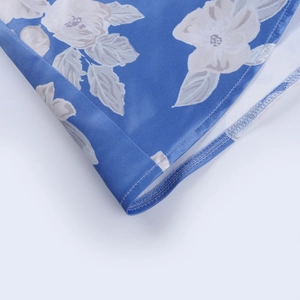 Close-up of floral print fabric with high-quality hem stitching on a blue summer dress