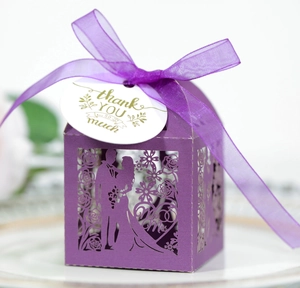 Close-up of laser-cut purple wedding favor box with Thank You tag and satin ribbon