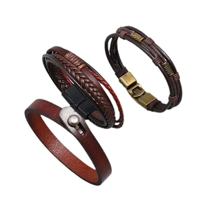 Set of three vintage brown woven leather bracelets with bronze metal clasps on white background