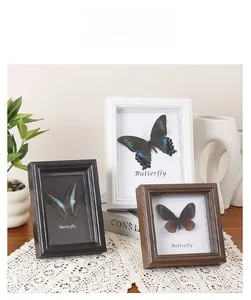 Close-up of three vintage wooden butterfly frames on lace with natural lighting