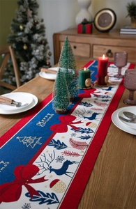 Close-up of jacquard Christmas table runner with reindeer motifs and Merry Christmas text