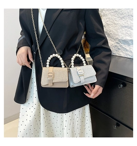 Detailed view of sequin mini square bag with pearl handle and golden chain straps