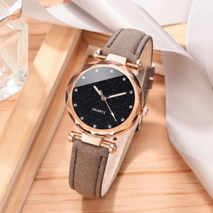Close-up of women's starry quartz watch with brown leather strap on elegant display