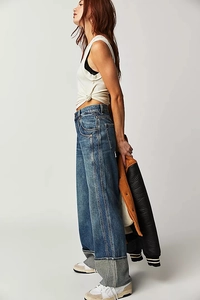 Detail of high-waisted wide-leg jeans featuring unique light grey contrast cuff folds