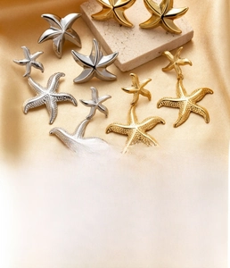 Detailed view of starfish earrings in gold and silver finish with vacuum plating texture
