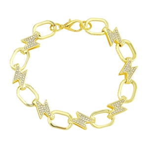 Macro detail of a gold chain necklace with alternating oval links and crystal lightning charms