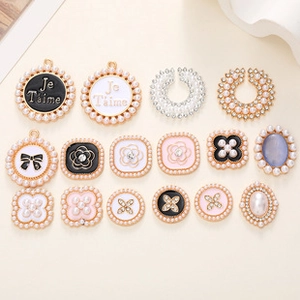Detail of assorted DIY alloy charms with enamel, pearls and camellia patterns