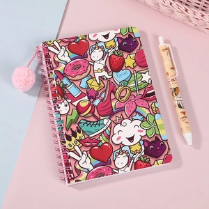 Detalle del cuaderno de espiral de unicornio con portada de garabatos y pompón de peluche