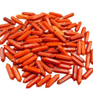 Pile of red hexagonal crystal pillars with double points on a clean white background