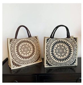 Detail of linen tote bags showing woven handles and geometric patterns in brown and black