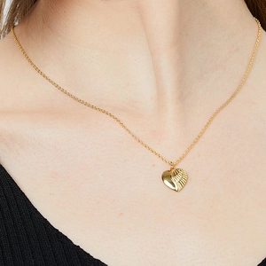 Fashionable gold necklace with heart and wing pendant on a female model neck