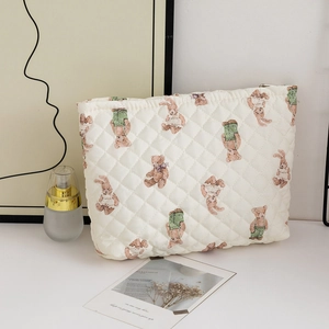 Detailed macro view of quilted makeup bag with cute cartoon bear and bunny patterns