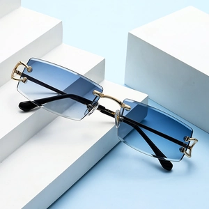 Detalle de gafas de sol sin montura con lentes degradadas azules y bisagra dorada