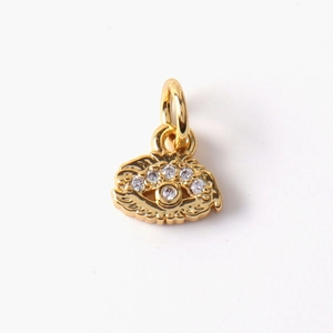 Macro detail of gold-plated evil eye shell pendant with sparkling cubic zirconia