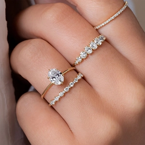Detail of luxury 18K gold ring set with oval cut diamond and sparkling pavé bands