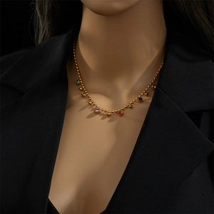 Gouden kralenketting met veelkleurige edelsteenhangers gedragen door een model