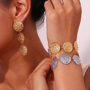 Dettaglio del bracciale placcato oro 18K con dischi martellati e orecchini coordinati