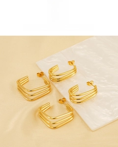 Detail of 18K gold plated triple-layer geometric earrings on elegant marble surface