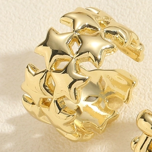 Macro detail of gold-plated star weave ring with polished finish on leather surface