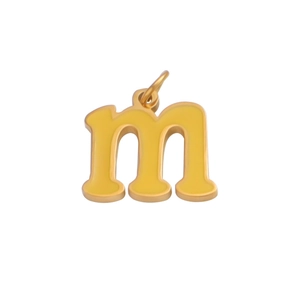 Close-up of golden stainless steel letter m pendant with yellow enamel inlay for DIY jewelry