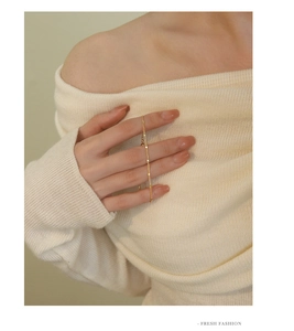 Close-up of a delicate gold chain bracelet with minimalist rectangular charms on a wrist