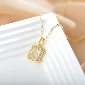 Detailed macro view of a rectangle emerald-cut clear crystal pendant in gold finish